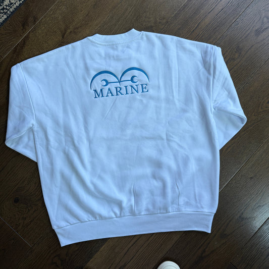 White towel with 'Marine' logo on a wooden floor