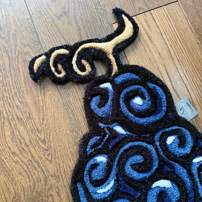 Decorative rug with blue and black spiral pattern on a wooden floor